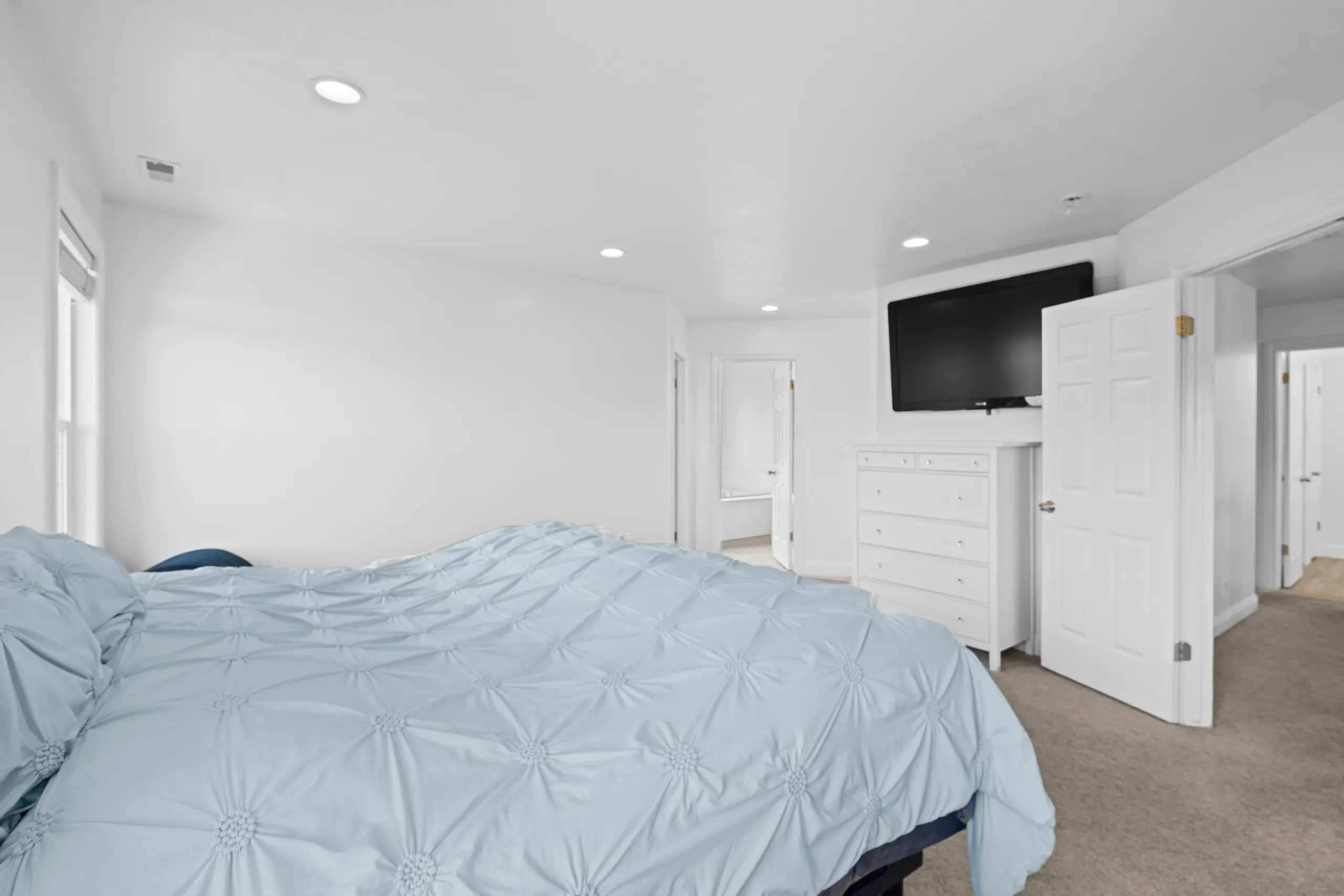 Primary bedroom with a king bed, recessed lighting and a doorway through to the en-suite bathroom
